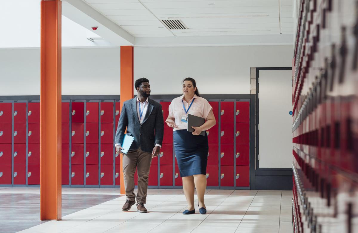 2 teachers walking in front of lockers