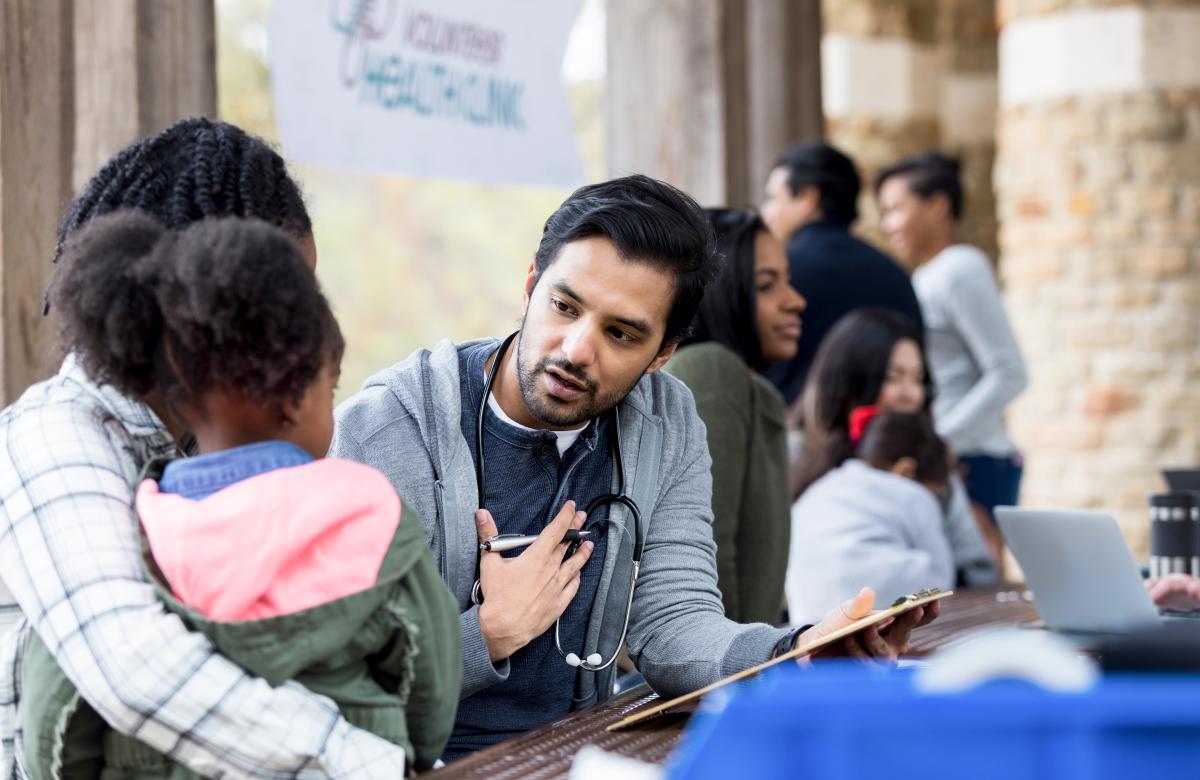 A doctor talking with a parent and child at a community health clinic 