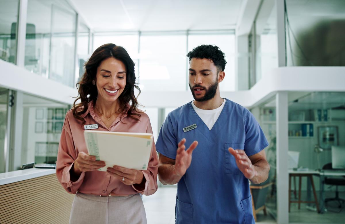 A stock photo of a hospital administrator and a physician conversing