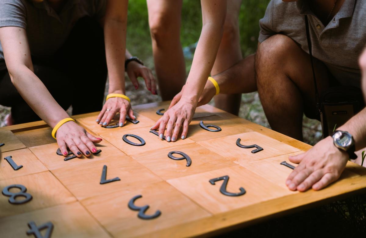 A group of people working on a large number puzzle