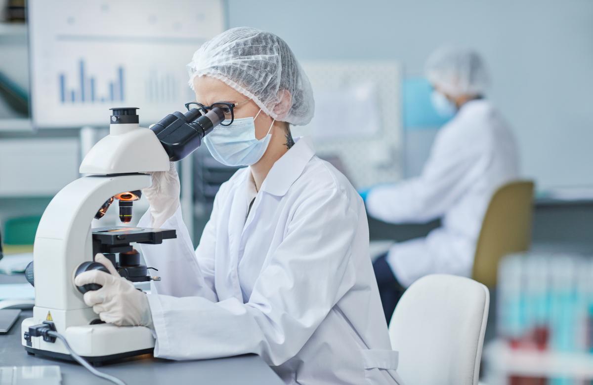 a woman looking through a microscope